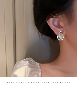 Macro view of elegant cat's eye stud earrings with rhinestone interlocking C design