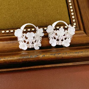 Elegant flower basket hoop earrings with zircons and pearls on vintage background
