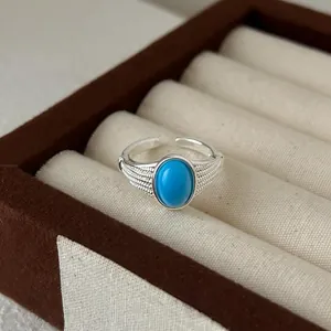 Detailaufnahme eines hochwertigen silbernen offenen Rings mit blauem Cabochon-Stein
