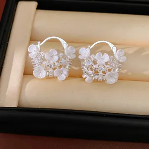 Close-up of elegant flower basket earrings featuring white pearls and sparkling zircons