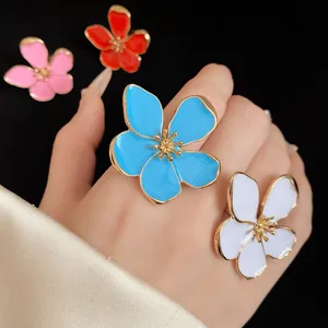 Detailed view of oversized enamel flower rings in vibrant blue, white, pink and red colors