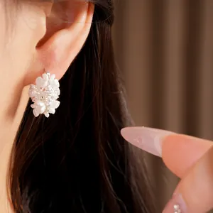 Close-up of elegant white flower basket earrings with sparkling cubic zirconia