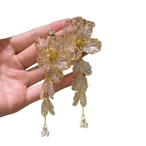 Elegant pink acrylic flower tassel earrings with rhinestone center in gold-tone metal