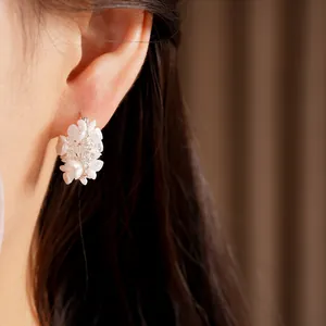 Detail view of sweet floral zirconia earrings worn on ear showing intricate design