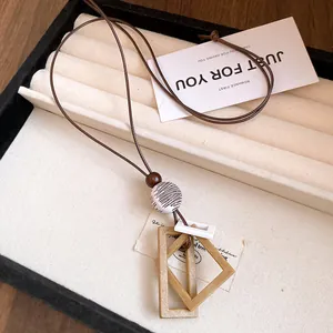 Vue macro détaillée du pendentif géométrique minimaliste en résine et bois sur plateau