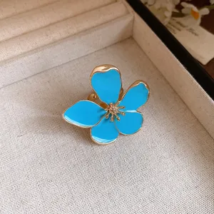Macro view of blue enamel flower petals and golden stamen on a retro ring of luxury