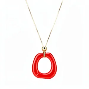 Minimalist long sweater chain with a large red irregular resin ring pendant on a gold chain.