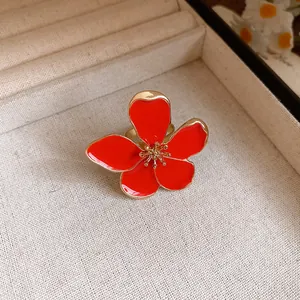 Close-up of retro red enamel flower open ring with exquisite gold stamen detail