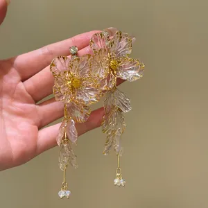 Detailed view of translucent acrylic flower earrings with delicate tassel drops