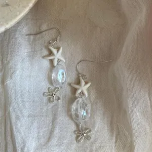 Dettaglio orecchini a stella marina stile vacanza con perline trasparenti e fiori