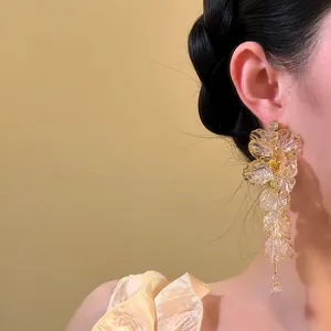 Detail view of long acrylic flower tassel earring with delicate translucent petals