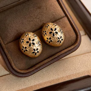 French vintage gold stud earrings with black enamel flower pattern and hammered texture