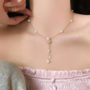 Detailed macro view of elegant 18K gold plated necklace with pearls and zircon pendant.