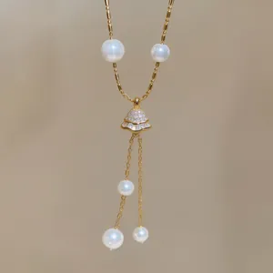Close-up of elegant 18K gold plated necklace with zirconia pavé pendant and pearls.