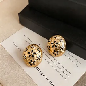 French vintage gold-tone oval stud earrings featuring black flower pattern textures