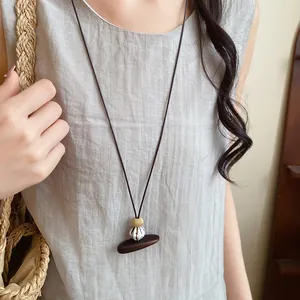 Vue détaillée d'un collier en cuir avec pendentif en bois et perles en résine