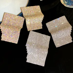 Detailed view of glittering silver and gold rhinestone-set geometric square stud earrings
