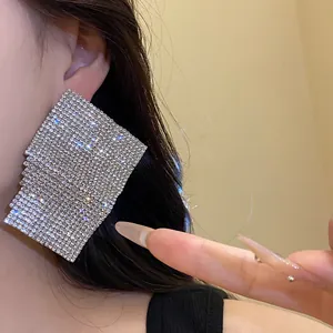 Macro view of oversized geometric square earrings with sparkling crystal rhinestones
