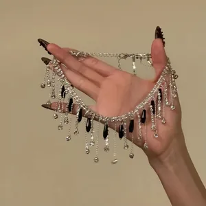 Handheld detailed view of beaded silver choker necklace with black teardrop fringe pendants