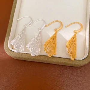 Détail de boucles d'oreilles pendantes ajourées dorées et argentées pour femmes élégantes