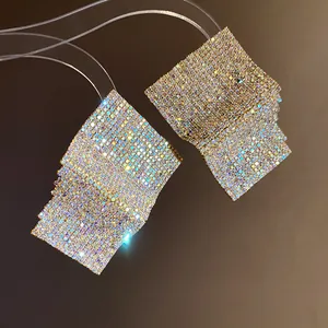 Detailed view of geometric square stud earrings with dense iridescent rhinestone pavé.