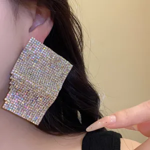 Close-up detail showing sparkling square rhinestone stud earrings worn on model ear