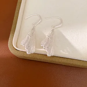 Vue détaillée de l'élégante texture ajourée et du design de ces boucles d'oreilles en argent.