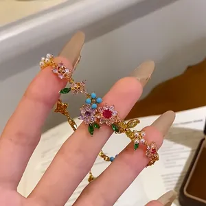 Detailed view of colorful zircon flower and pearl bracelet in 18k gold plating