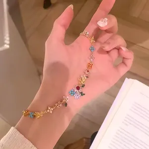Close-up of 18k gold-plated bracelet featuring colorful zircon flowers and pearls