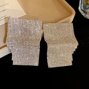 Close-up of geometric square earrings encrusted with sparkling rhinestones