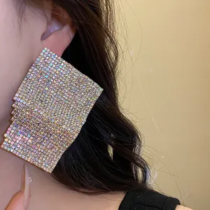 Detailed view of large geometric square stud earrings with shimmering rhinestones