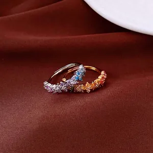 Elegantes anillos estilo Jardín de Monet con piedras coloridas sobre fondo de tela roja oscura