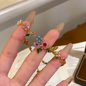 Close-up of 18k gold plated bracelet with colorful CZ flowers and pearls on hand