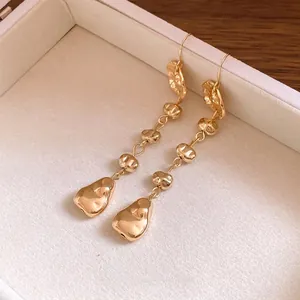 Boucles d'oreilles pendantes dorées irrégulières dans une boîte à bijoux de luxe