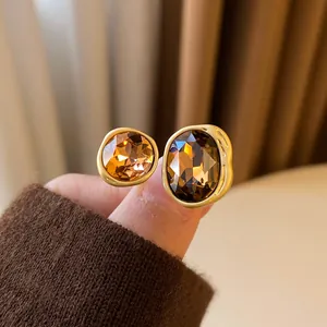 Close-up of a vintage Maillard-style gold open ring with oval and round amber crystals