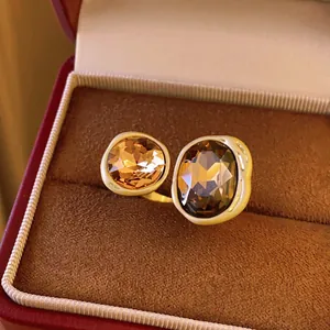 Close-up of vintage gold open ring featuring large amber and smoky faceted gemstones