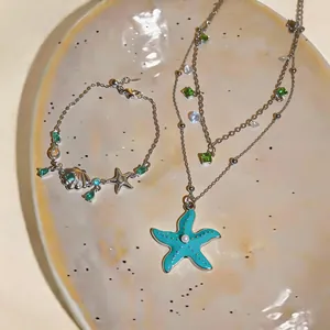 Close-up detail view of elegant zircon starfish and shell necklace and bracelet jewelry set
