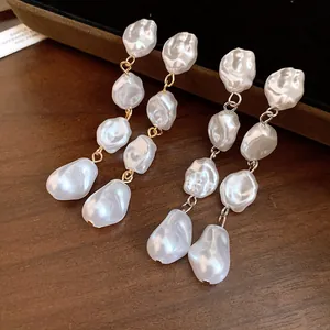 Primo piano di eleganti orecchini vintage francesi con perle barocche irregolari.