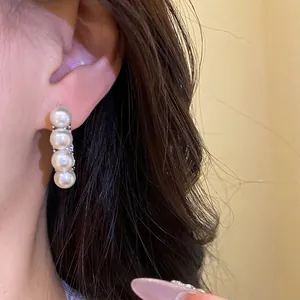 Eleganti orecchini a cerchio con perle in stile vintage francese su una modella