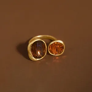 Exquisite detail of a matte gold open ring featuring brown oval crystals in Maillard style