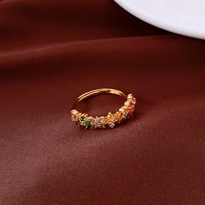 Primer plano de un anillo dorado estilo Jardín de Monet con gemas florales de colores.