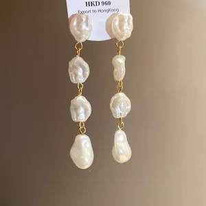 Dettaglio ravvicinato di orecchini vintage francesi con perle barocche irregolari.