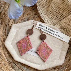 Vue détaillée des boucles d'oreilles bohèmes en bois en forme de losange et fleurs