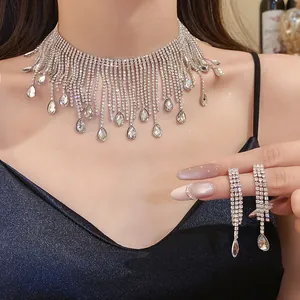 Close-up of sparkling rhinestone teardrop tassel necklace and earring set on a model