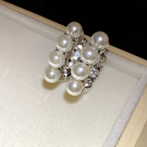Macro di orecchini retrò francesi con perle bianche e cristalli in una confezione