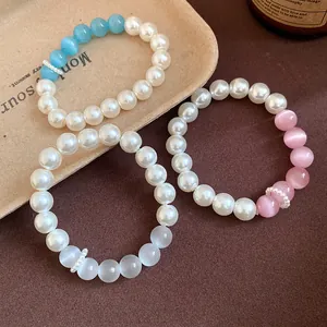 Close-up of cat-eye stone and pearl beaded bracelets in blue, pink, and white