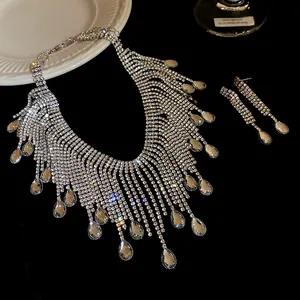 Close-up of elegant rhinestone teardrop fringe necklace and earrings set.