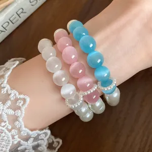 Close-up of cat's eye stone and pearl beaded bracelets in pink, blue, and white