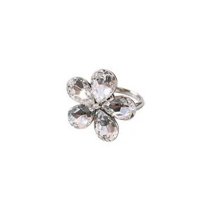 Bague fleur étincelante argentée avec cinq pétales en cristal sur un fond blanc
