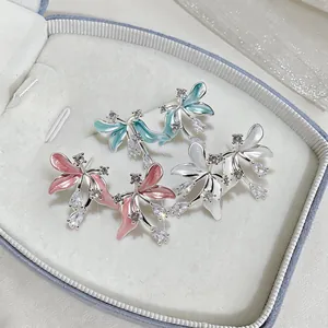 Vue détaillée de boucles d'oreilles fleurs en émail rose, bleu et blanc avec zirconiums.